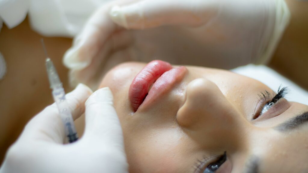 Cosmetic specialist performing lip filler procedure to improve lip symmetry and fullness